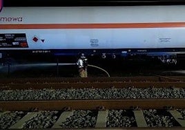 Un bombero extingue las llamas del vagón afectado del tren.