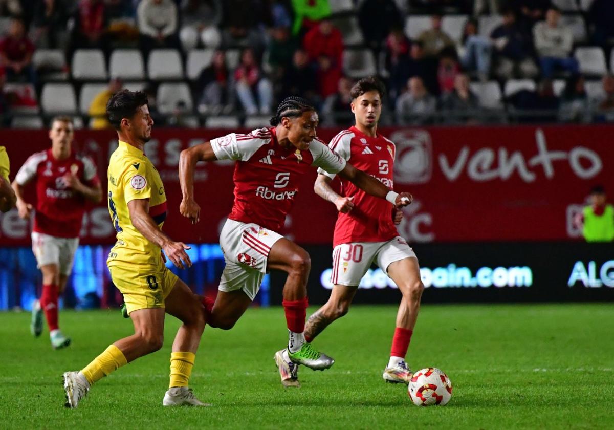 Rojas conduce el balón ante la mirada de Palmberg, recambios ayer en el Real Murcia.