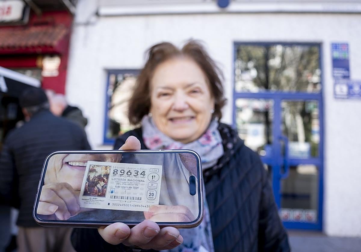 Una ganadora de la Lotería del Niño enseña su décimo premiado