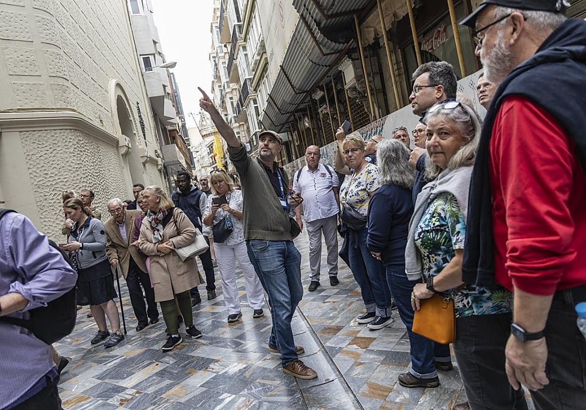 Un guía oficial, con un grupo, en la calle Mayor.