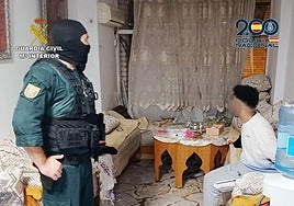 Un agente de la operación con uno de los detenidos.