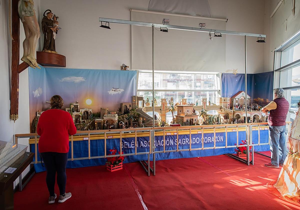 Dos visitantes observan el nacimiento expuesto en la iglesia del Sagrado Corazón de Torrevieja.