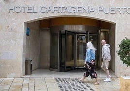 Dos visitantes pasan delante de la puerta del hotel Cartagena Puerto, ayer.