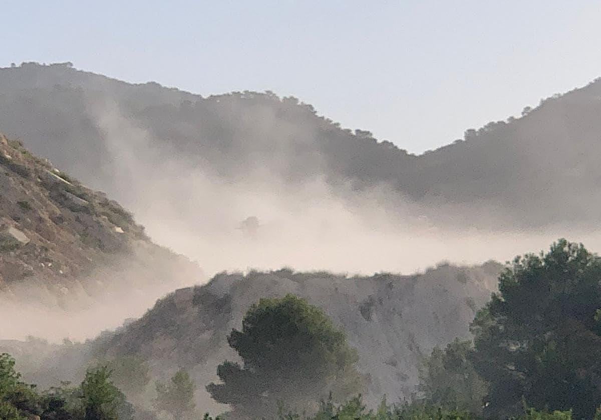 Polvareda en dispersión provocada por la planta de molienda de la Cantera 'Santa Rita VI', de Colina Cimar SL, que oculta las instalaciones.