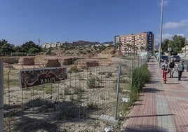 Tres vecinos pasan frente al terreno donde en marzo de este año comenzaron las obras de la Escuela Infantil, junto al Parque de la Rosa, actualmente detenidas.