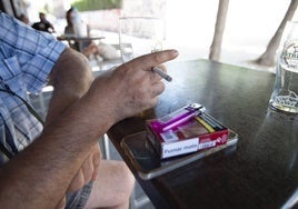 Un hombre fuma en una terraza de Murcia.