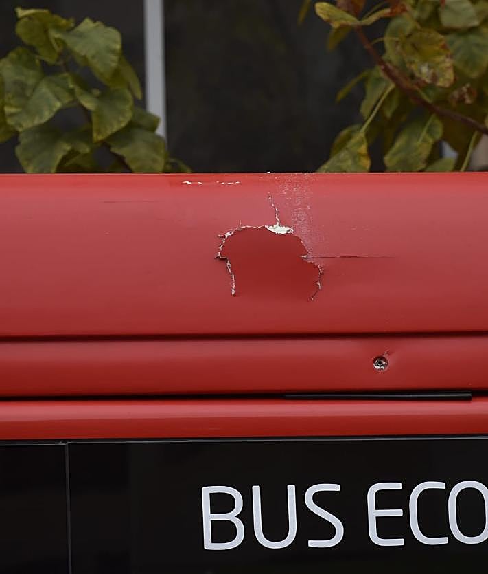 Imagen secundaria 2 - Retenciones en la vía, un investigador realiza fotos del lugar del impacto y daños en el autobús tras la caída del hombre.