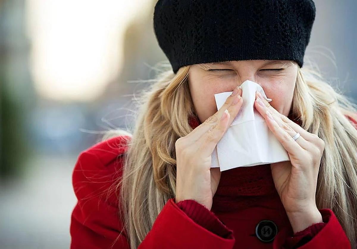 Mujer resfriada se limpia con un pañuelo.