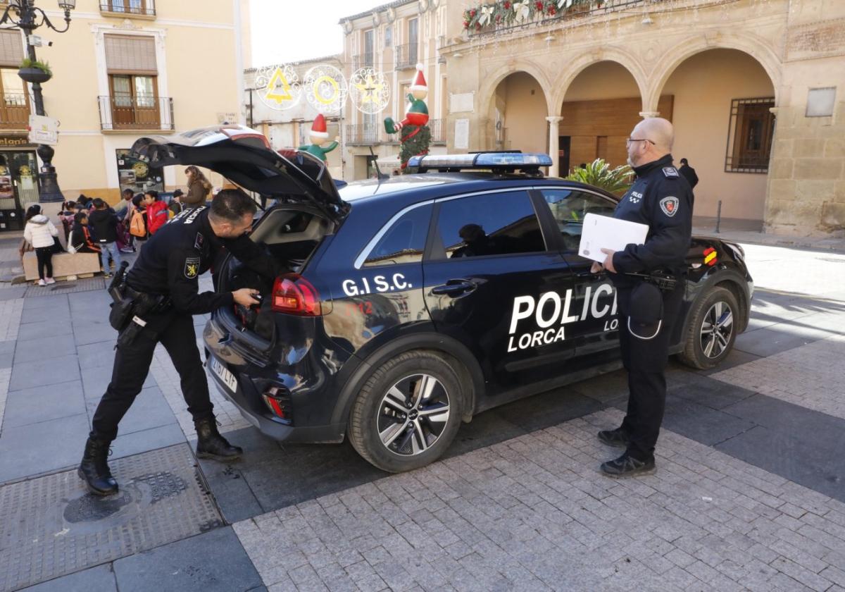 El jefe de la Policía Local (d) y uno de los agentes junto a un coche patrulla.