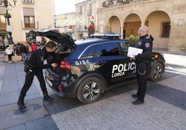 El jefe de la Policía Local (d) y uno de los agentes junto a un coche patrulla.