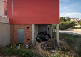 Enseres y basura acumulados en la fachada trasera del edificio.