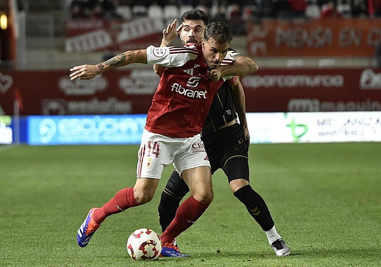 Pedro León es agarrado por un rival en el partido contra el Intercity.