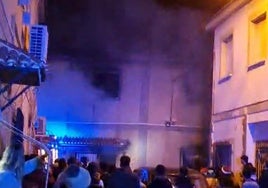 Humo saliendo de la vivienda incendiada este domingo por la noche.