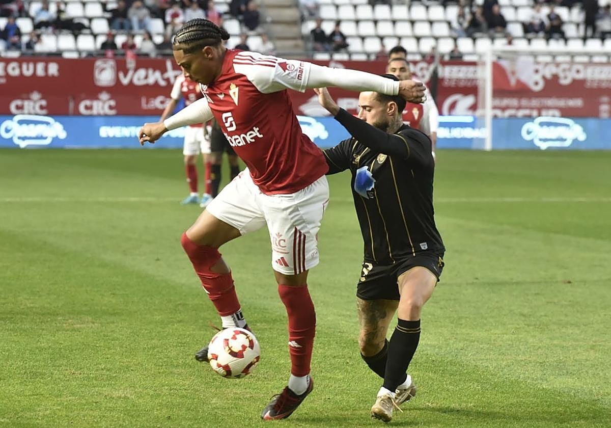 Carlos Rojas intenta marcharse de un defensor.