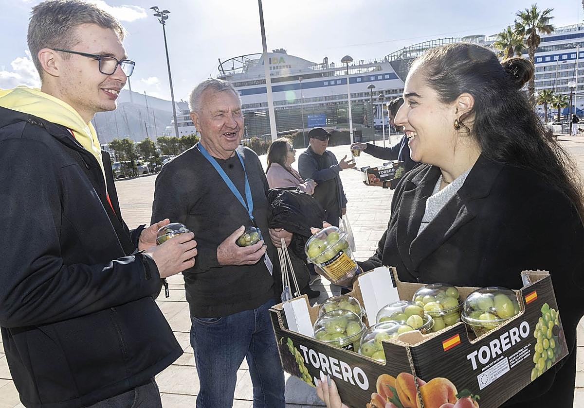 Reparto de paquetes con quince uvas entre turistas que llegaron este jueves en el 'Aidadiva' a Cartagena.