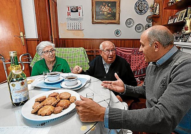 Antonia Abril y Ramón Guirao comparten en su casa un café con Gregorio Morales, voluntario y responsable del proyecto Simeón de Cáritas contra la soledad no deseada.