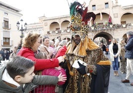 Los niños saludan al rey Baltasar a su llegada a la plaza de España.