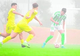 Paco Esteban, goleador del Betis, entre jugadores del Real Murcia.