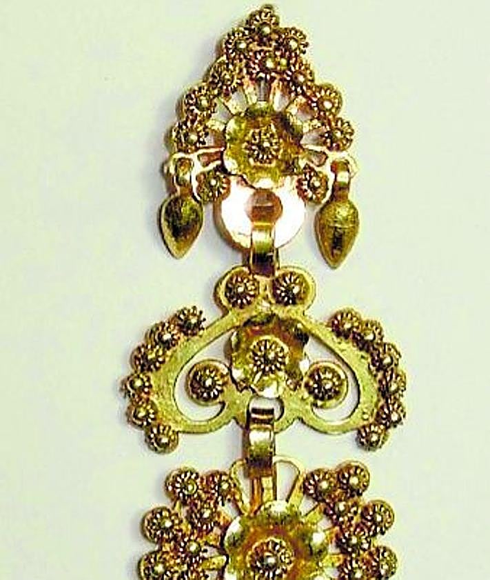 Imagen secundaria 2 - La blusa infantil que el museo data a finales del siglo XVIII en Alcaraz y que no se expone al público, la misteriosa Cruz de Caravaca que posee el museo y una de las impresionantes arracadas de la época del califato omeya.