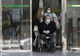 Pacientes con mascarilla, este lunes en los accesos al Reina Sofía.