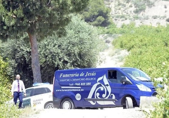 Un vehículo de la Guardia Civil y otro del servicio funerario en el lugar de un siniestro.