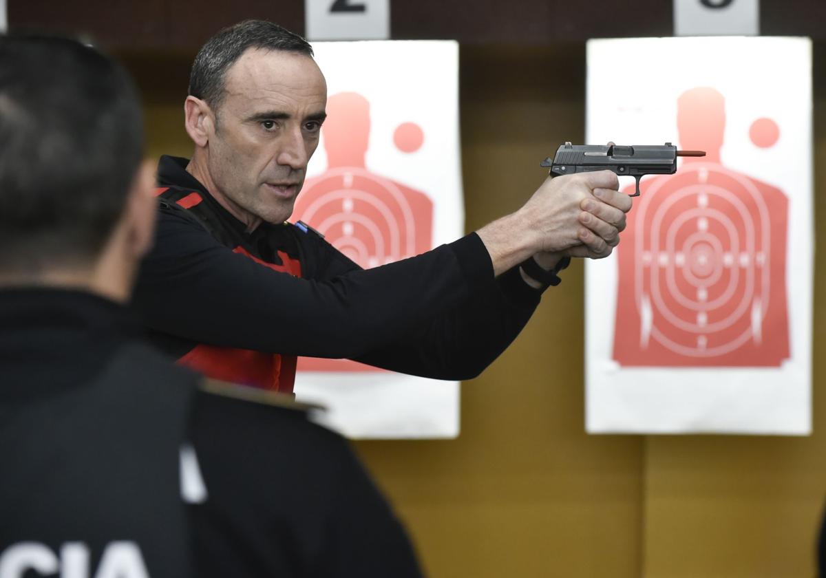 Un instructor de tiro explica cómo apuntar con el arma a agentes de la Policía Local de Las Torres de Cotillas en la galería de tiro de Murcia.