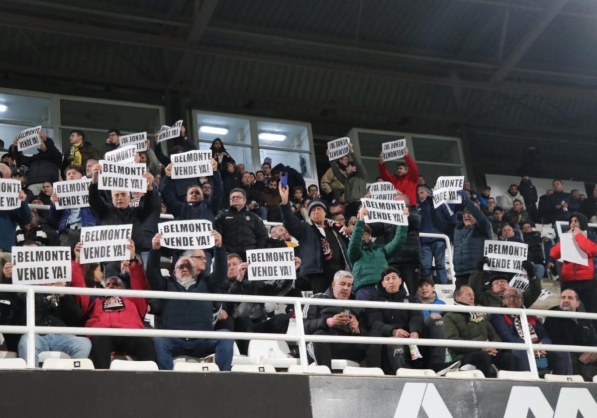 Aficionados de tribuna muestran carteles pidiendo la venta del club a Paco Belmonte, este viernes contra el Oviedo.