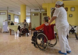 Una empleada acompaña a una anciana en una residencia de Murcia, en una imagen de archivo.