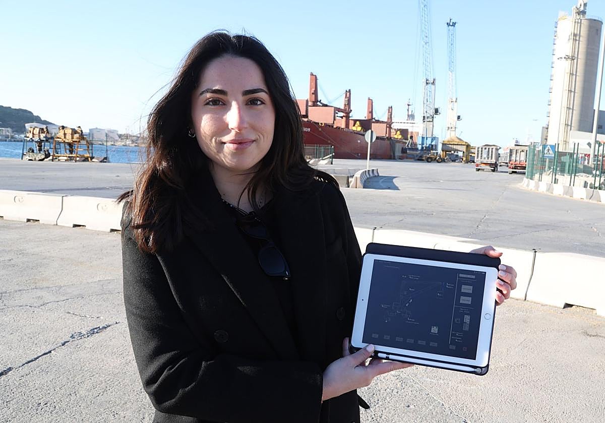 María Segado, en la dársena de Escombreras, mostrando un esquema de su trabajo para el modelo de grúas que operan al fondo.