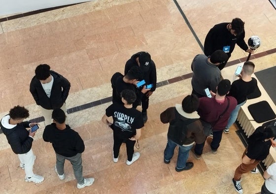 Unos jóvenes esperan en Murcia para registrar su iris en el centro comercial Nueva Condomina de Murcia el 20 de febrero de 2024.