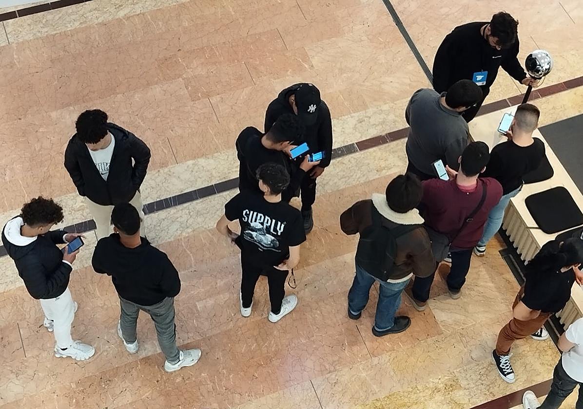 Unos jóvenes esperan en Murcia para registrar su iris en el centro comercial Nueva Condomina de Murcia el 20 de febrero de 2024.
