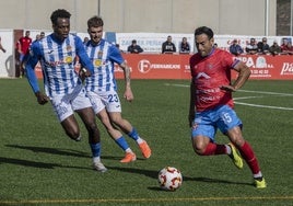 Petcoff, de la Minera, conduce el balón en presencia de Kensly y Ekiza, del Águilas.