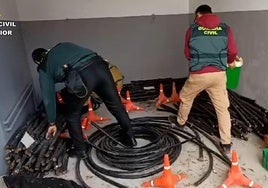 Dos guardias civiles junto a cables de cobre recuperados.