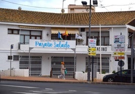 Una mujer pasea ante la puerta del Casino, entre las avenidas de Las Salinas y Lo Pagán.