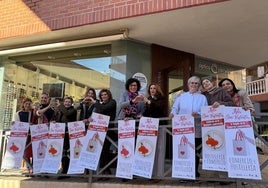 Autoridades y comerciantes portan los carteles de la campaña.