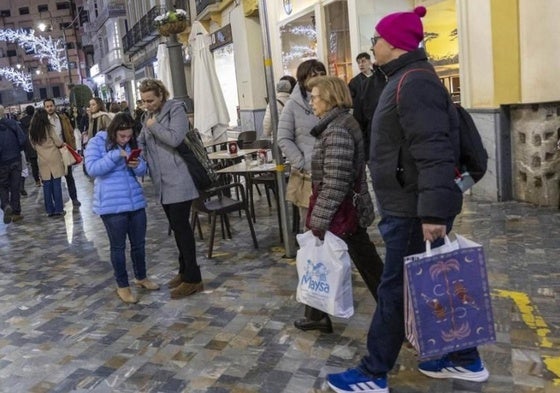 Personas con bolsas paseando por la calle puerta de Murcia repleta de personas en una imagen de archivo.