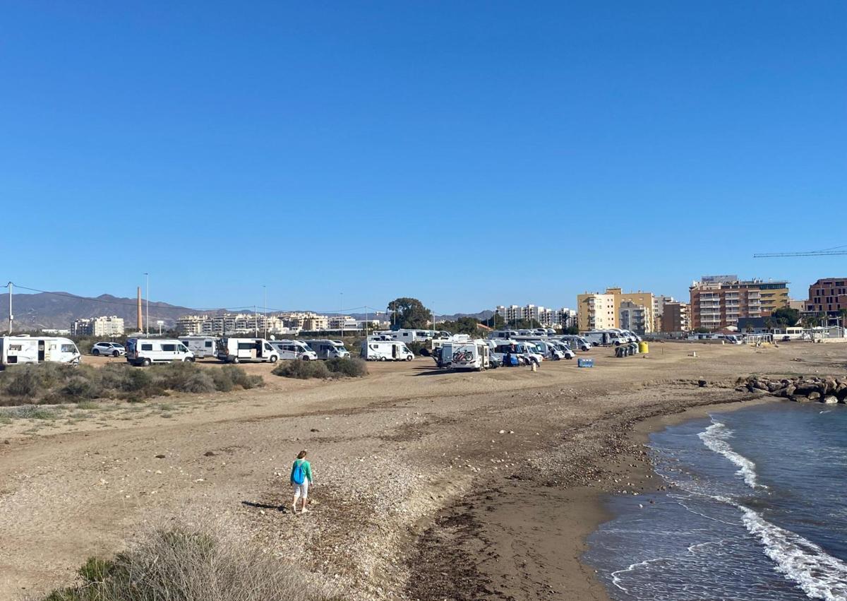 Imagen secundaria 1 - Panorámica de la playa de la Casica Verde, entre el puerto deportivo y Matalentisco, con numerosas caravanas aparcadas al borde de la playa. Detalle de algunas de las autocaravanas instaladas junto a la playa de la Casica Verde con elementos como sillas, mesas o tumbonas desplegados en el exterior.