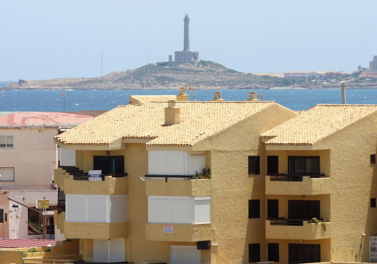 Pisos en un bloque de La Manga con el faro de Cabo de Palos al fondo, en una imagen de archivo.