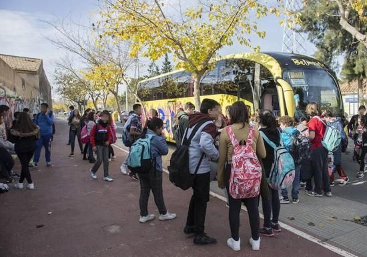 Alumnos alrededor de un autobús escolar, en una imagen de archivo.