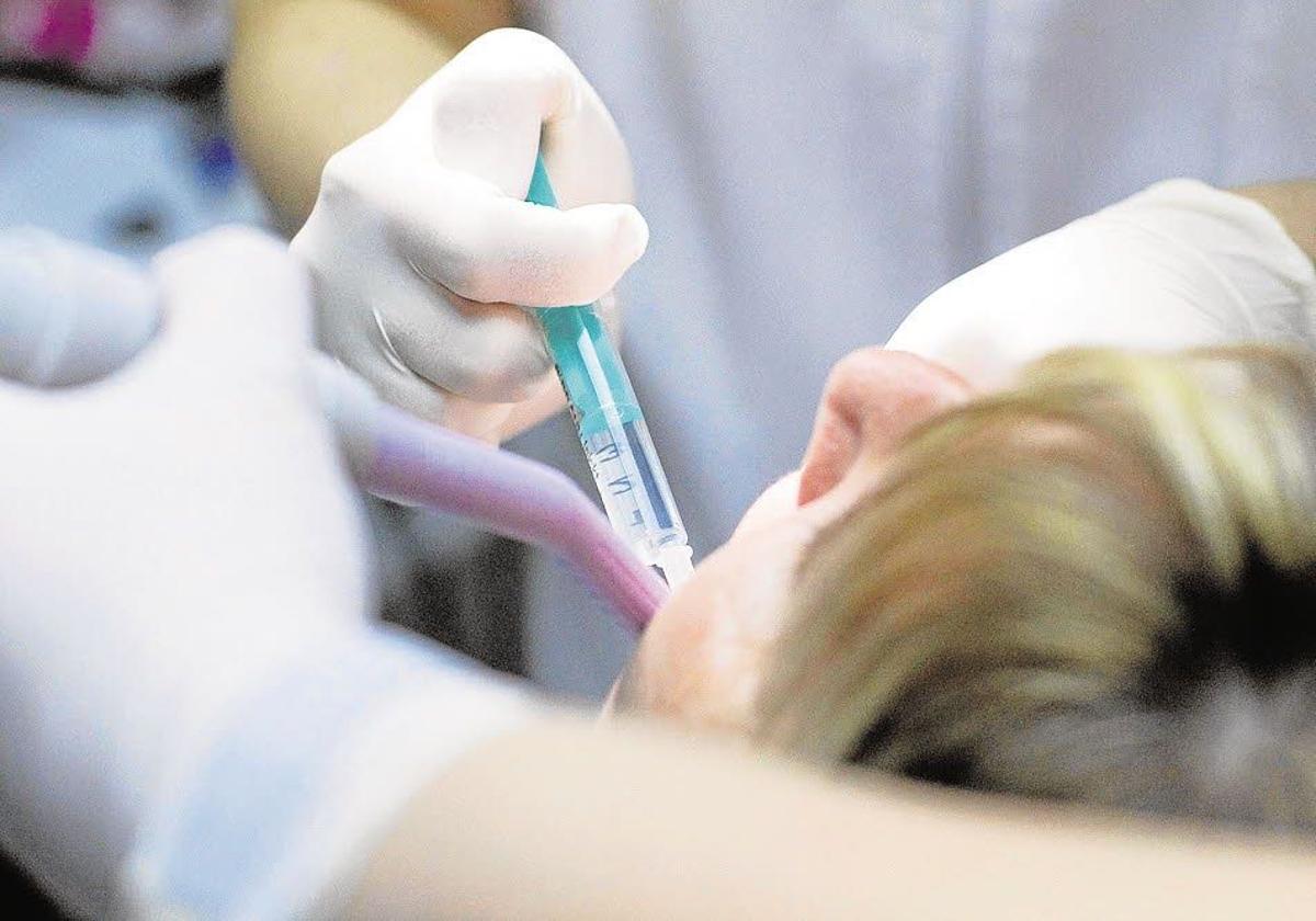 Un dentista trata a una paciente en una imagen de archivo.