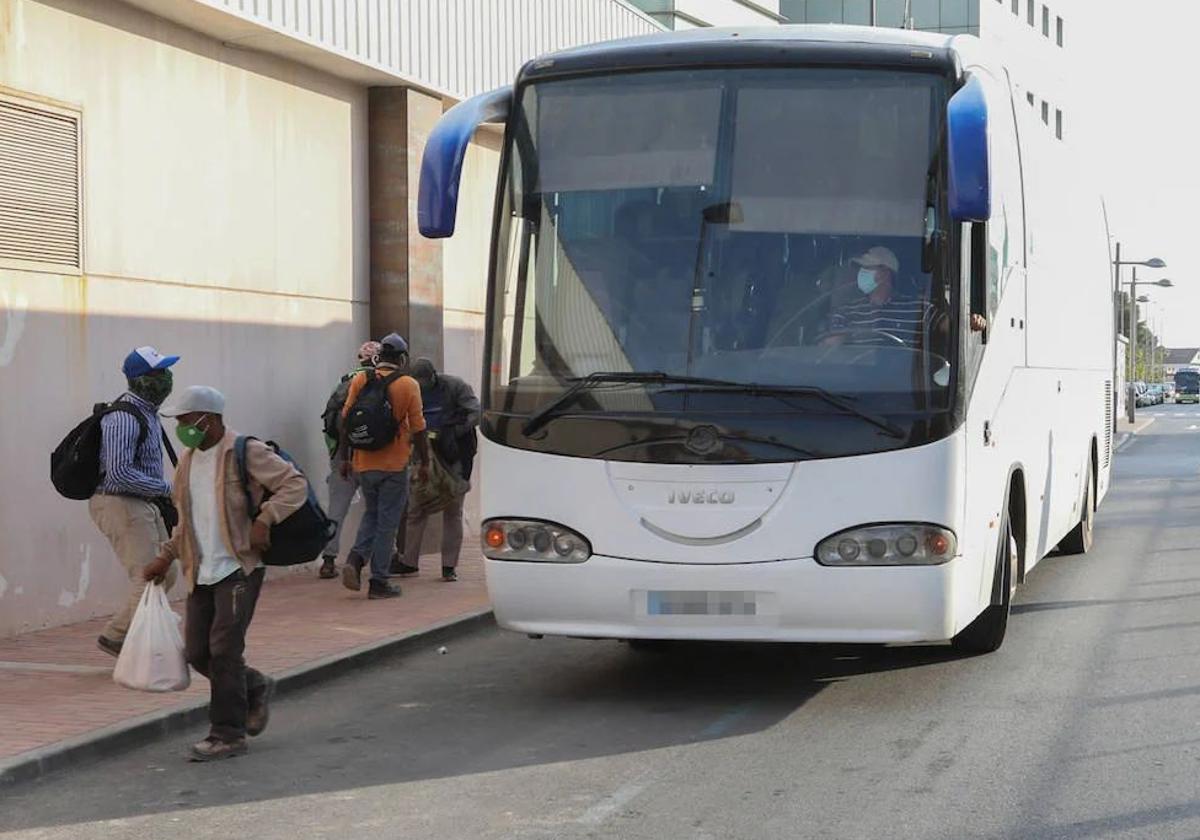 Varios jornaleros se bajan del autobús que les lleva a su zona de trabajo, en una imagen de archivo.