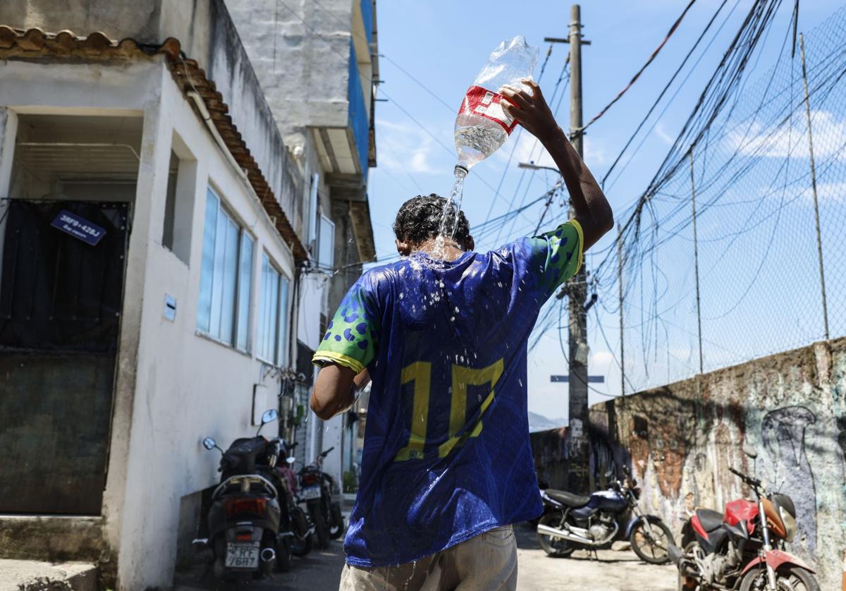 Un joven se refresca en una favela.