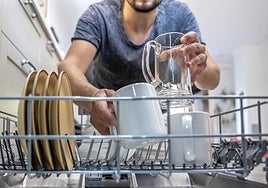 Imagen de archivo de un persona limpiando un lavavajillas.