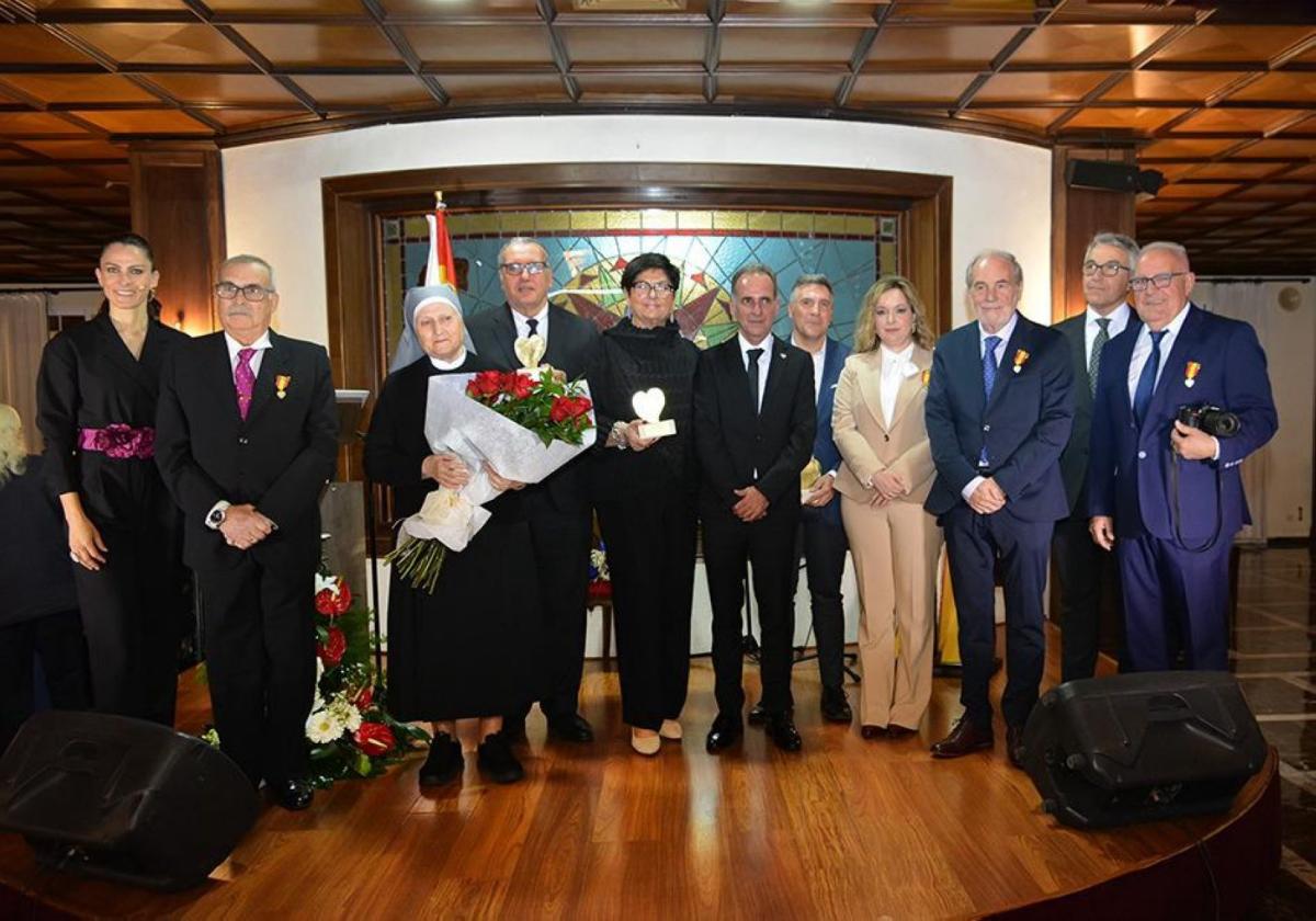 Foto de familia de los galardonados con las medallas y corazones.