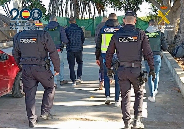 Agentes de la Policía Nacional y la Guardia Civil trasladan a los detenidos.