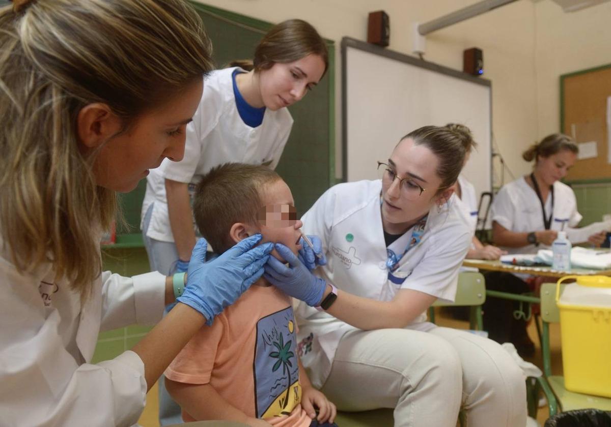 Un niño recibe la vacuna de la gripe en un colegio de Murcia, en la última temporada.