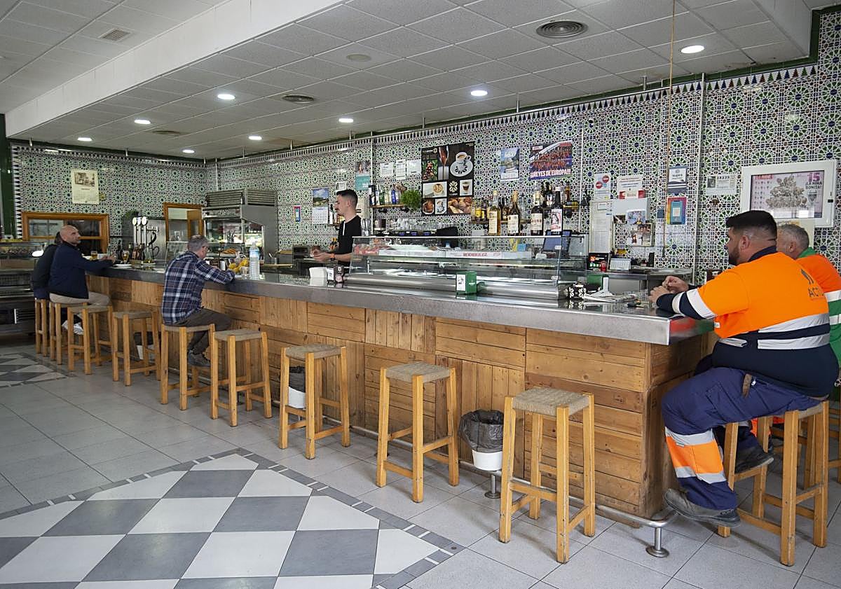 Imagen principal - Trabajadores, pizarra con el menú y asado del restaurante Las Palmeras IV.