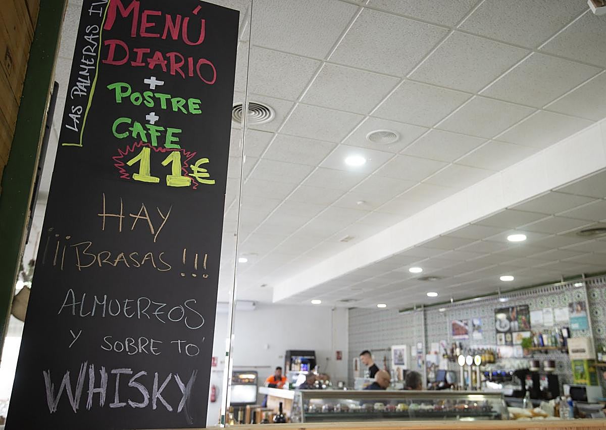 Imagen secundaria 1 - Trabajadores, pizarra con el menú y asado del restaurante Las Palmeras IV.