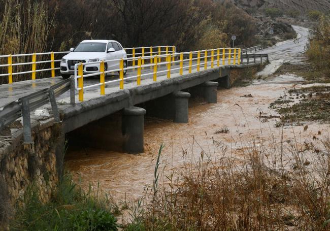 Un vehículo cruza el puente del camino de Curtís durante la crecida del río Mula por el temporal, ayer por la tarde.