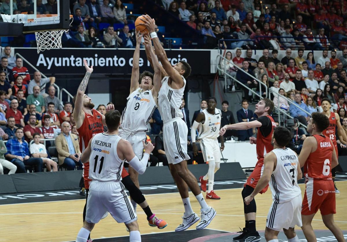 Entre Hugo González y Edy Tavares capturan un rebote en el UCAM-Real Madrid de la ida.